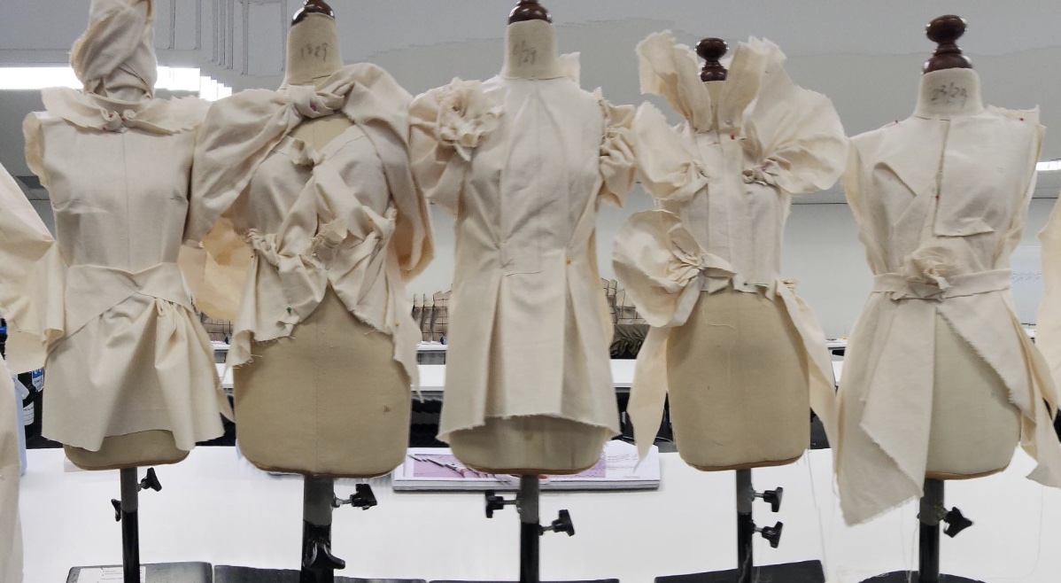 Mannequins wearing cream coloured garments.