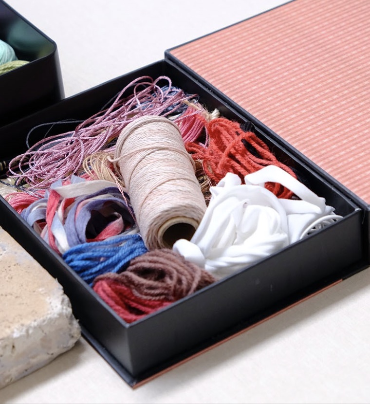 A container of sewing threads.
