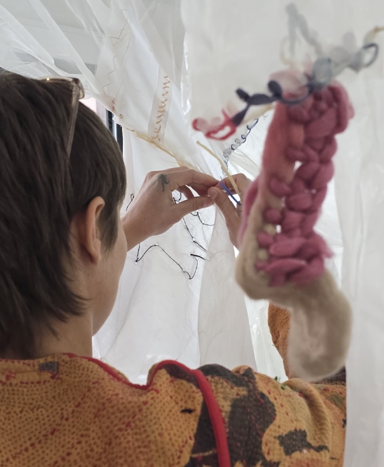 A person making with fabric and thread.